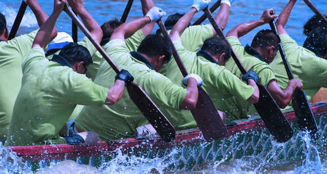 People paddling in a canoe in coordination