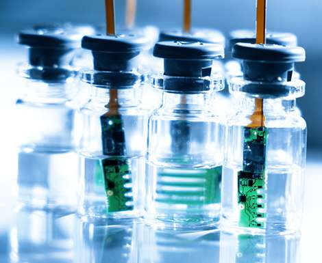 Liquid-filled vials arranged in a straight line on a shelf.