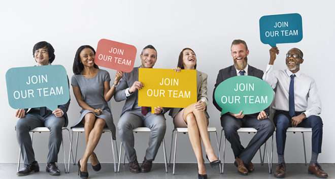 6 people smiling while holding signs with the text: "join our team"